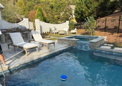 Finished pool and spa with loungers and screen panels at Greystone Dream